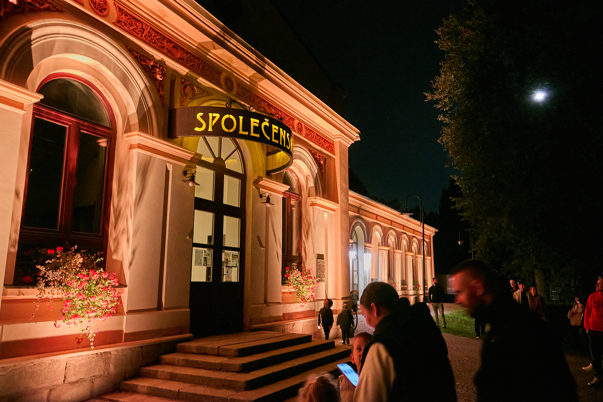 Vchod do Společenského domu po setmění